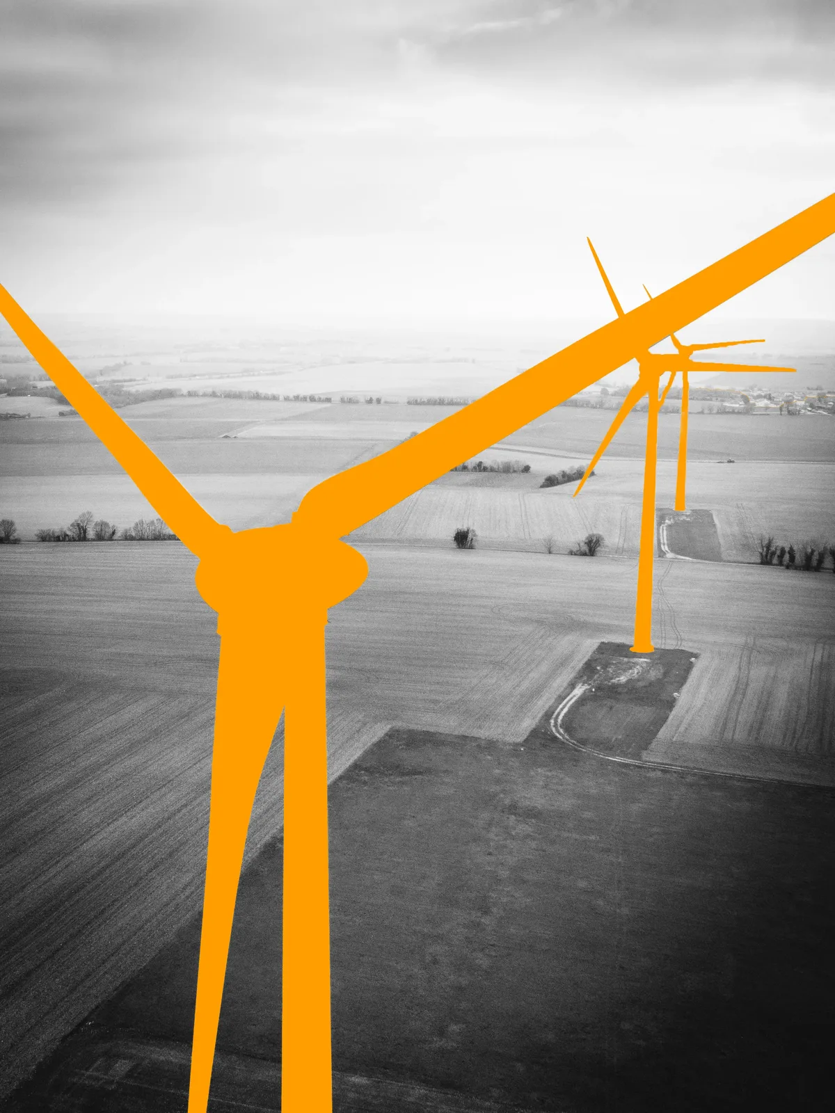 Aerial view of wind turbines, highlighted in orange, standing in open farmland